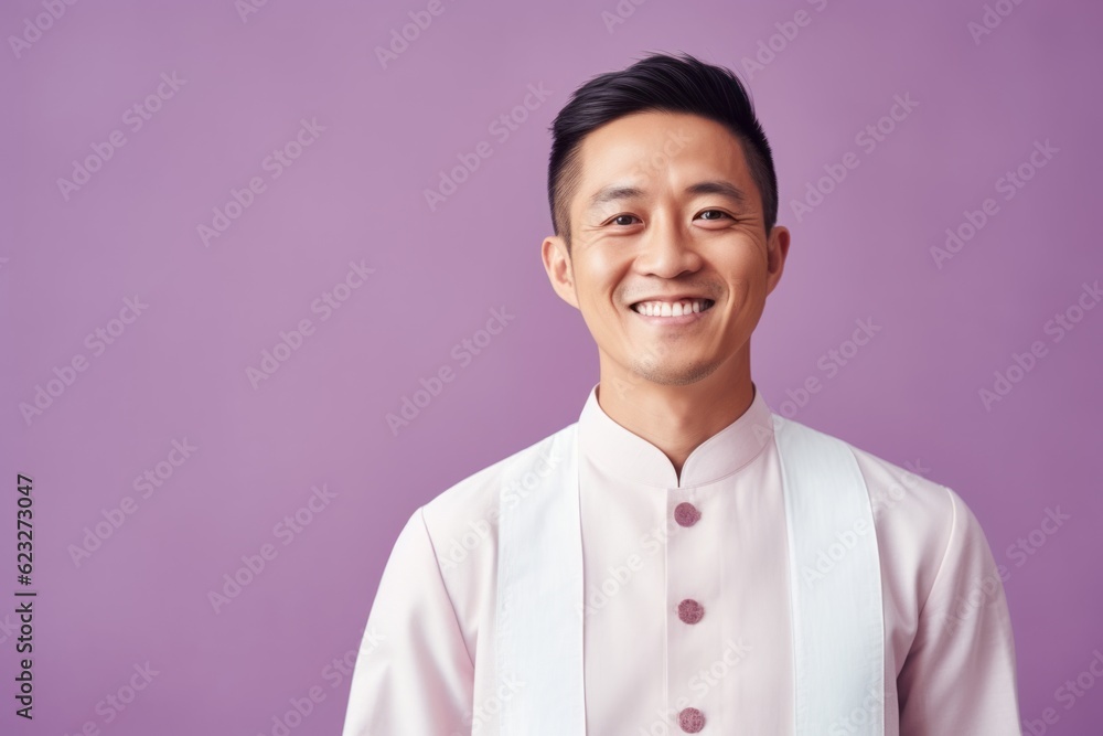 Portrait of a happy young asian man, isolated on purple background