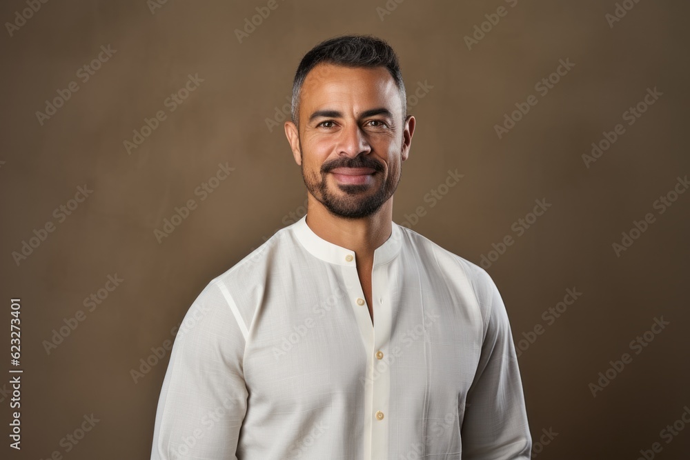 Portrait of handsome bearded Indian man in white shirt looking at camera Portrait of handsome bearded Indian man in white shirt looking at camera