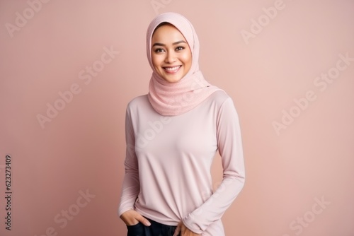 Hijab woman with pink t-shirt and jeans on pink background © Leon Waltz