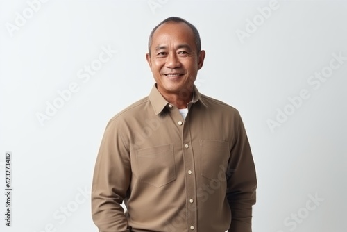 Portrait of a smiling mature asian man standing against white background
