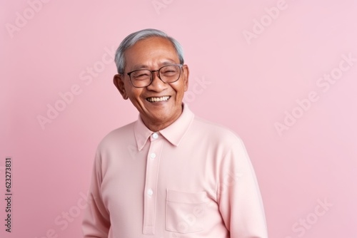 Portrait of happy asian senior man in pink shirt and eyeglasses