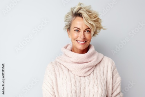 Portrait of a smiling middle aged woman in warm sweater and scarf