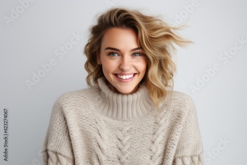 Portrait of a beautiful young woman with blond hair in knitted sweater