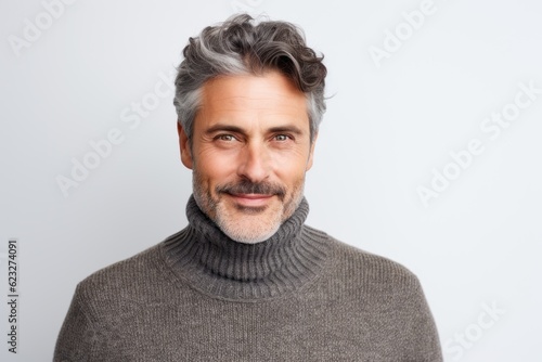 Portrait of a handsome middle-aged man with grey hair wearing a sweater