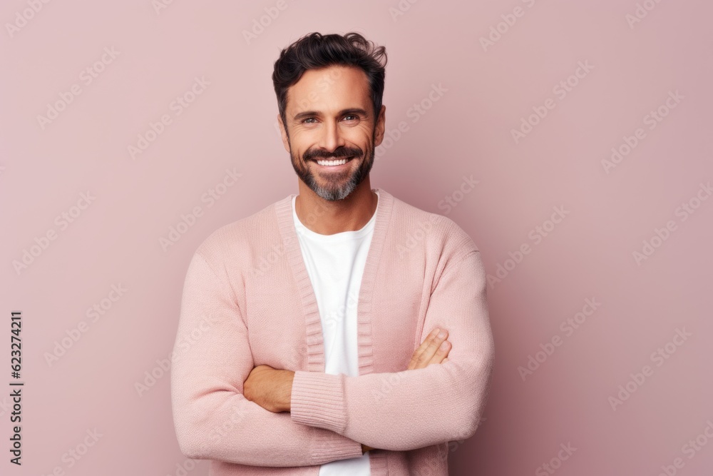 Portrait of handsome young man looking at camera and smiling while standing against pink background Portrait of handsome young man looking at camera and smiling while standing against pink background
