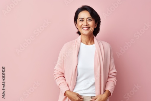 Portrait of smiling middle-aged woman in pink jacket over pink background