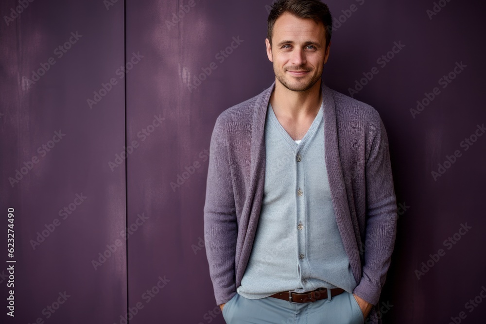 Portrait of a handsome young man in casual wear standing against purple wall Portrait of a handsome young man in casual wear standing against purple wall