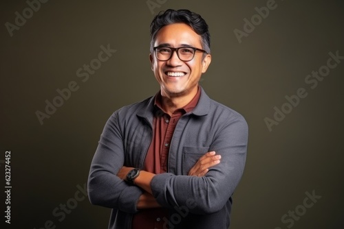 Young handsome Indian businessman against colored background. Man wearing eyeglasses © Eber Braun