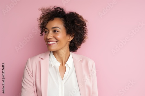 Portrait of a smiling african american businesswoman standing against pink background