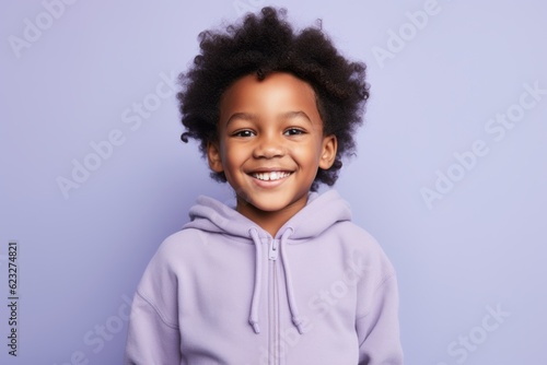 Happy little african american girl in violet hoodie on violet background © Leon Waltz