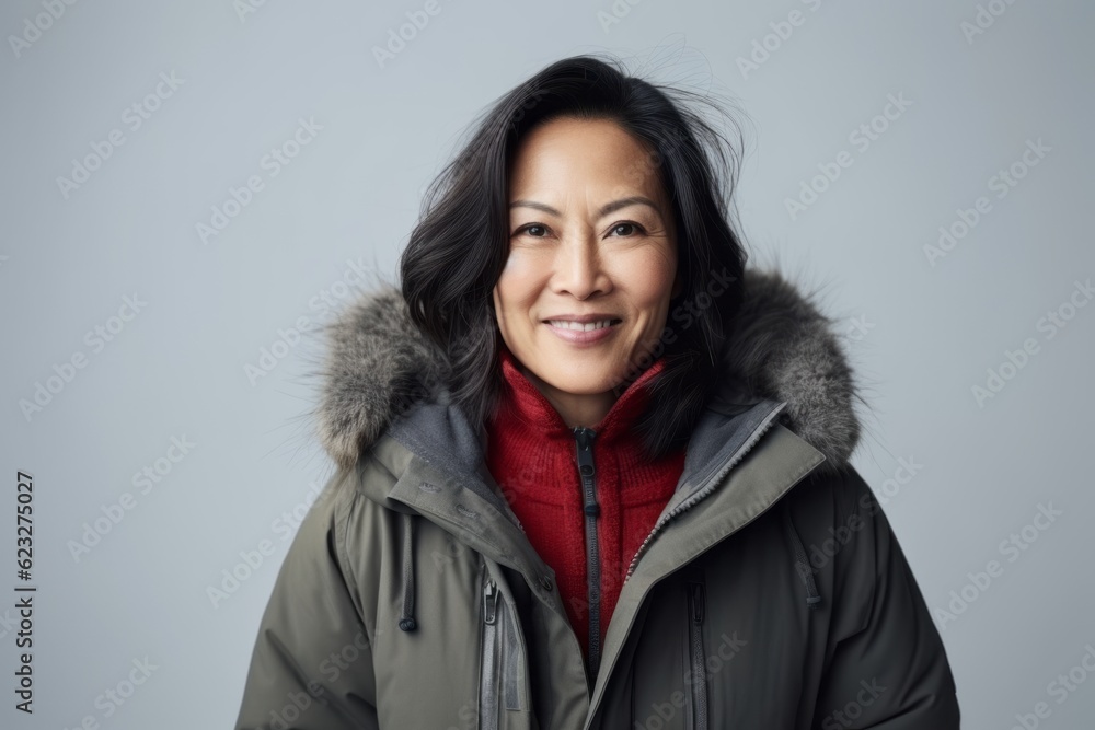Portrait of a smiling asian woman in winter jacket looking at camera Portrait of a smiling asian woman in winter jacket looking at camera