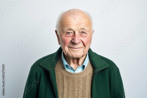 Portrait of an elderly man in a green sweater on a white background