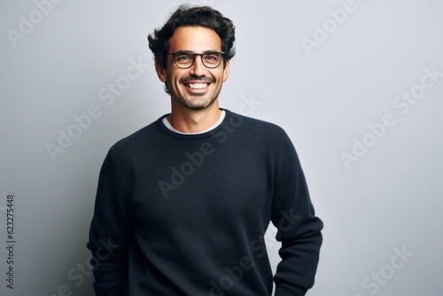 Portrait of a handsome young man wearing glasses and smiling at the camera