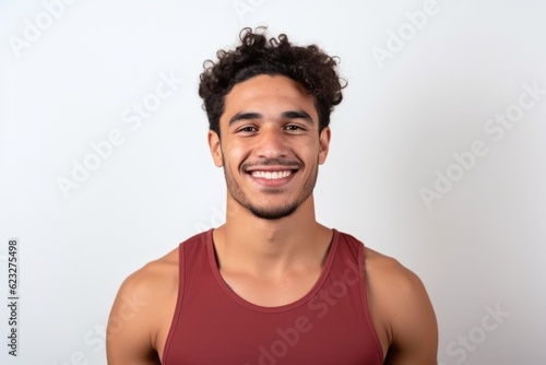 Portrait of young latin man with curly hair smiling against white background © Robert MEYNER