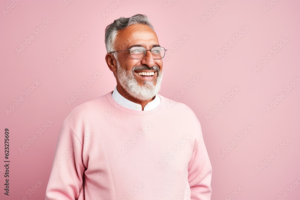 Portrait of a smiling senior man in pink sweater and glasses on a pink background Portrait of a smiling senior man in pink sweater and glasses on a pink background