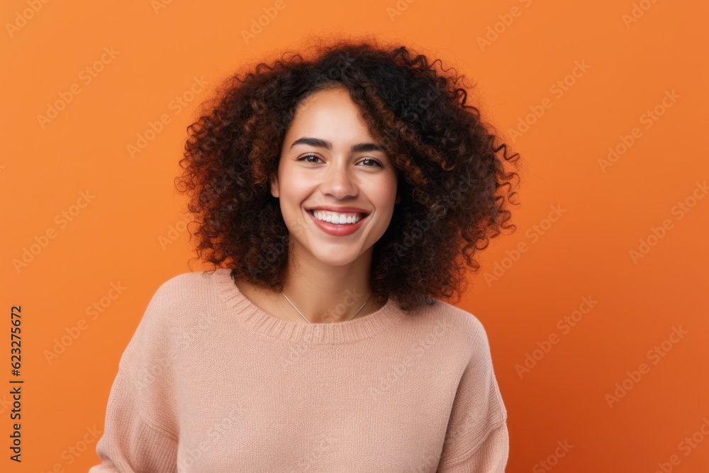 Cheerful african american woman looking at camera isolated over orange background Cheerful african american woman looking at camera isolated over orange background