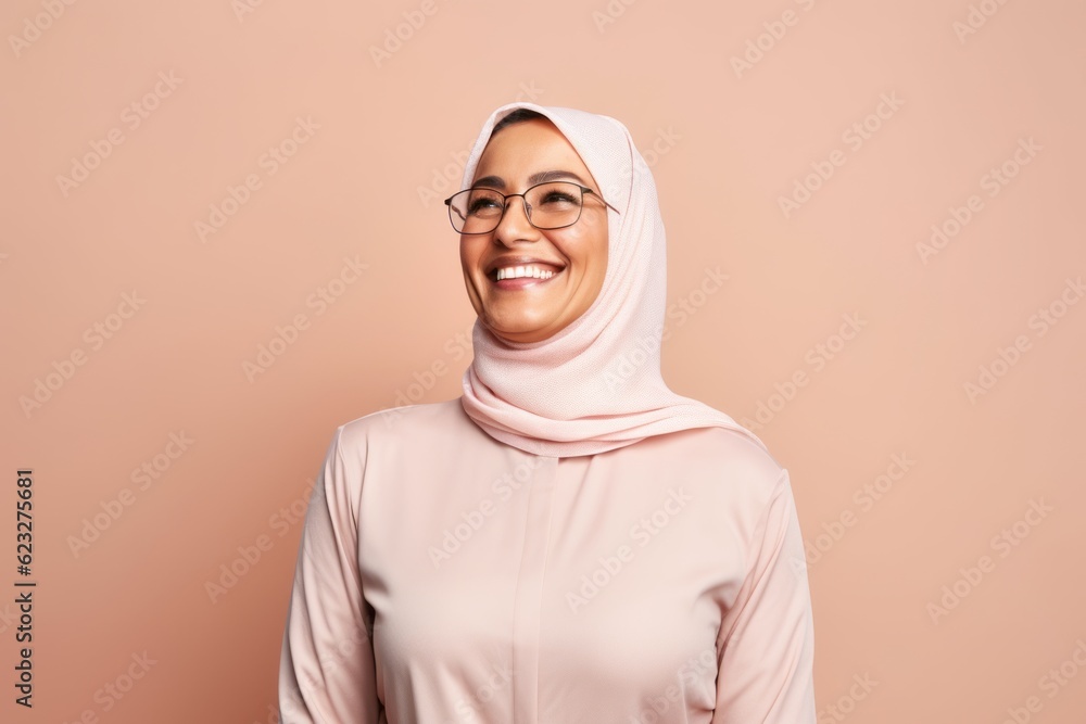 Portrait of a smiling young muslim woman wearing hijab and eyeglasses looking at camera Portrait of a smiling young muslim woman wearing hijab and eyeglasses looking at camera