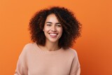 Cheerful african american woman looking at camera isolated over orange background