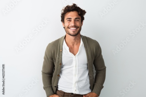 Lifestyle portrait photography of a satisfied Brazilian man in his 20s wearing a chic cardigan against a white background 