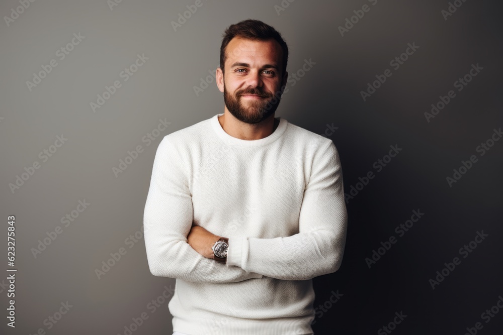 Portrait of a handsome bearded man in a white sweater on a gray background Portrait of a handsome bearded man in a white sweater on a gray background