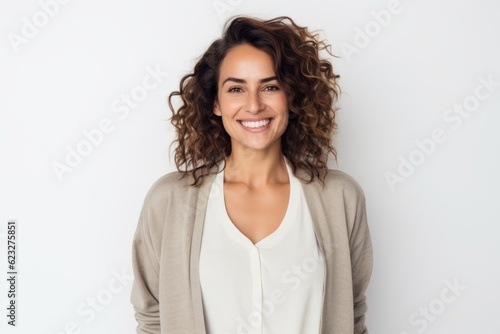 Portrait of beautiful young woman with curly hair smiling at camera against white background