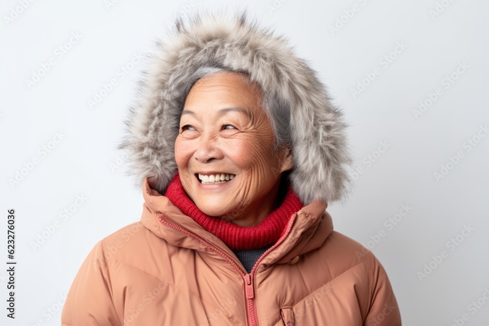senior asian woman wearing winter jacket and fur hat on white background senior asian woman wearing winter jacket and fur hat on white background