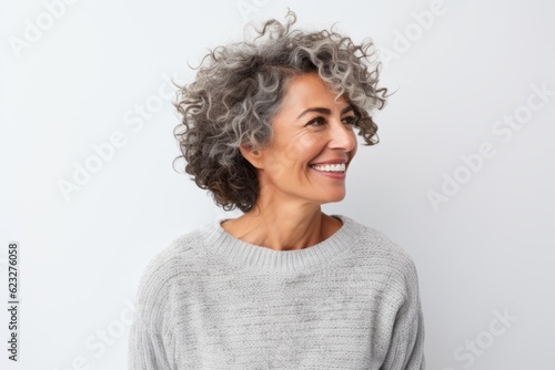 Portrait of a smiling mature woman with curly hair standing against white background