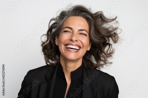 Lifestyle portrait photography of a happy Brazilian woman in her 50s wearing a sleek suit against a white background 