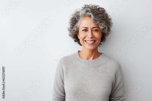 Portrait of a smiling senior woman with grey hair standing against white background