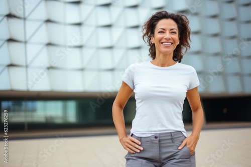 Portrait of a smiling businesswoman standing with hands on hips outdoors