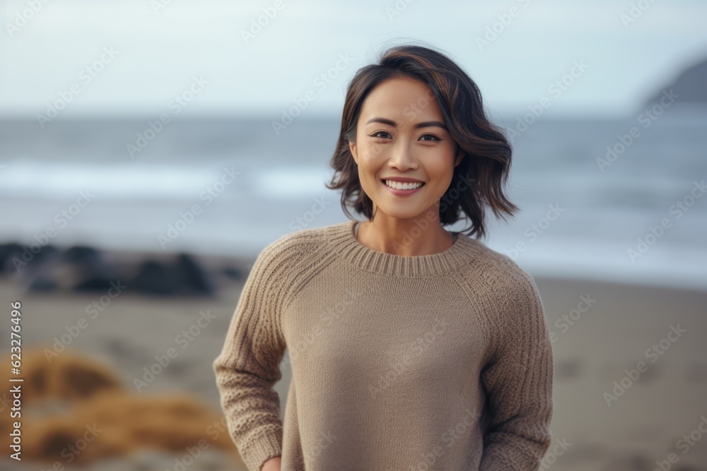 Portrait of smiling young woman standing on the beach at autumn day Portrait of smiling young woman standing on the beach at autumn day