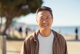 Portrait of happy asian senior man looking at camera in the beach