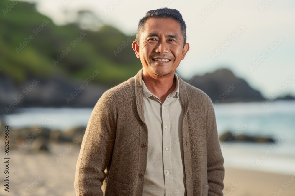 Portrait of happy mature man standing on beach and looking at camera Portrait of happy mature man standing on beach and looking at camera