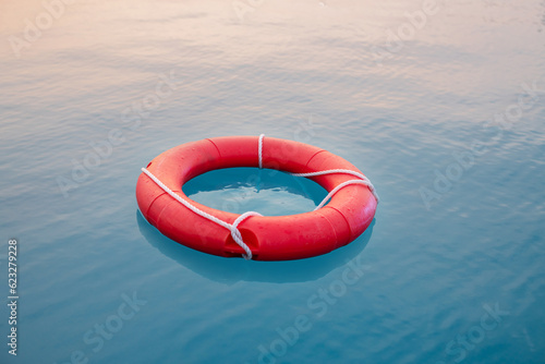 Red swim tube floating on blue water in water park for pubic security purpose.