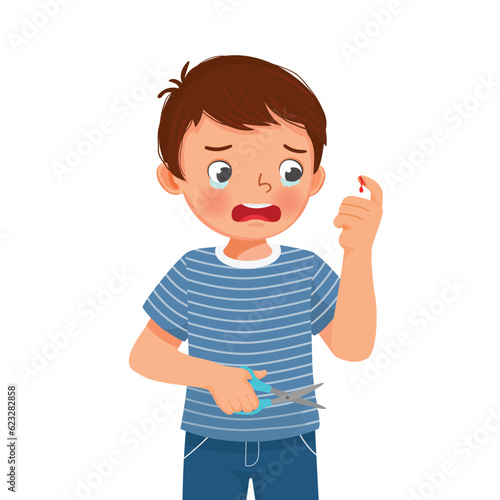Little boy cut his finger with scissor accidentally crying look at the wound bleeding with blood drop