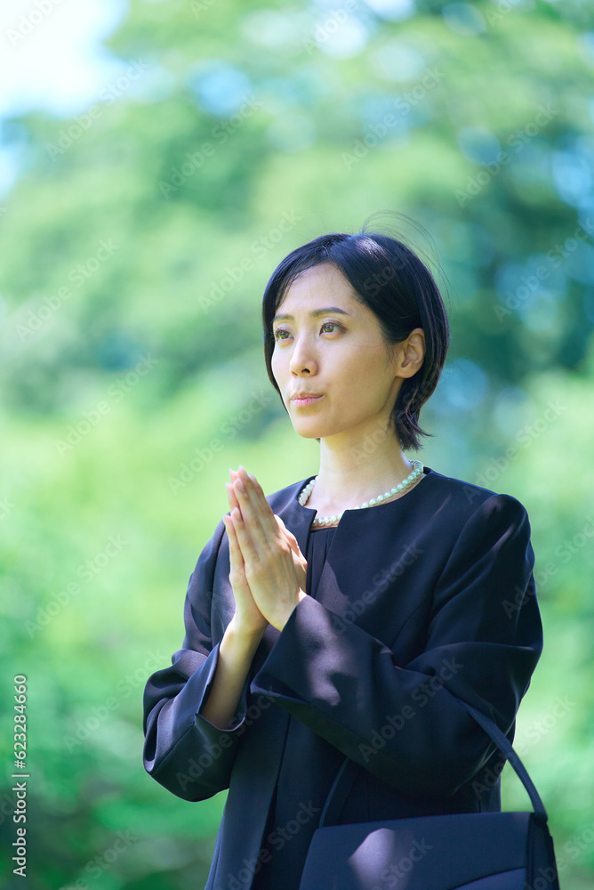 喪服姿で合掌する女性