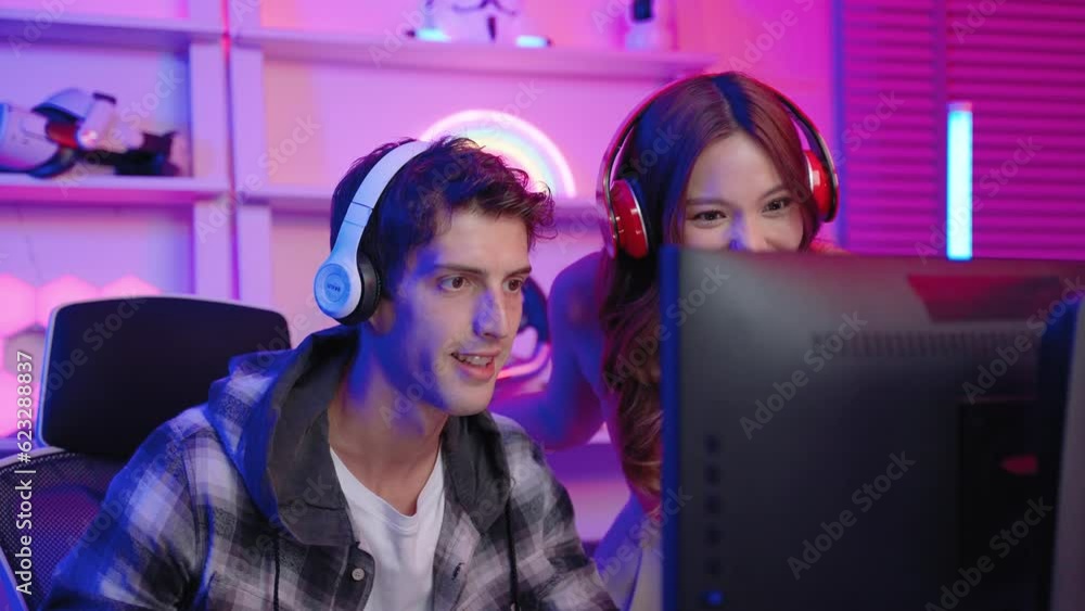 Influencer gamer couple playing games with joystick live streaming on social media in exciting neon atmosphere , technology concept, recreation
