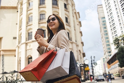 Cheerful Asian woman holding shopping bags.Beautiful Asian woman in casual style shopping in the city.