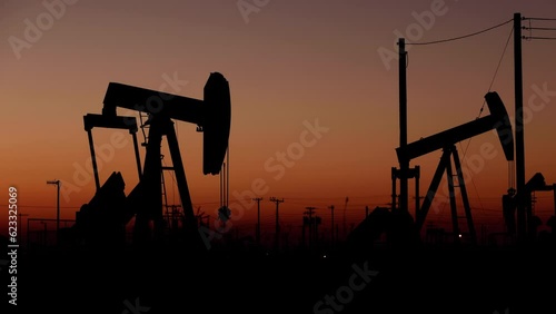 The sun rises behind oil pumps in California