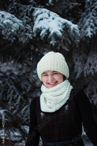 Woman is a young portrait. In a white hat on the street. Winter, Conifers