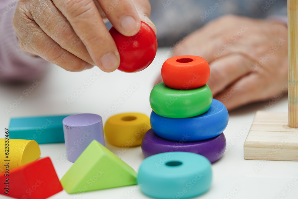 Asian elderly woman playing puzzles game to practice brain training for dementia prevention, Alzheimer disease. Asian elderly woman playing puzzles game to practice brain training for dementia prevention, Alzheimer disease.