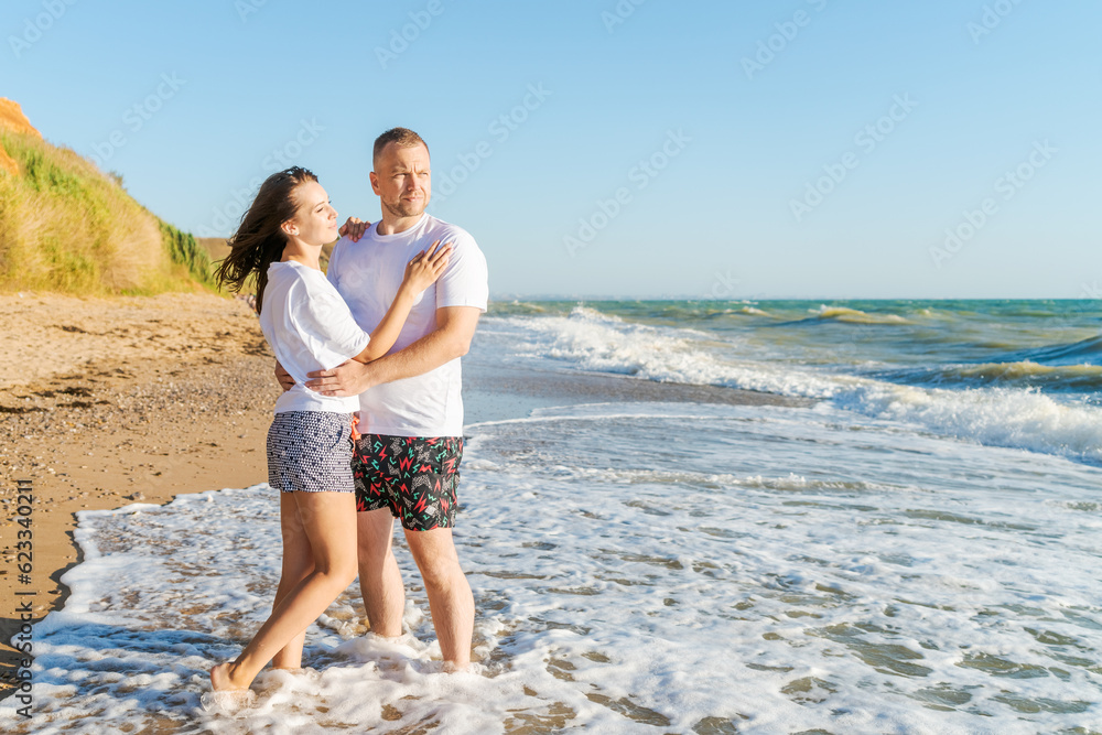 happy couple stand on the seashore on a sunny day, the concept of family and vacation happy couple stand on the seashore on a sunny day, the concept of family and vacation