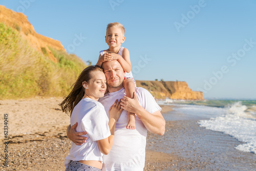 family with little son walk along seashore on a sunny day, the concept of family and vacation