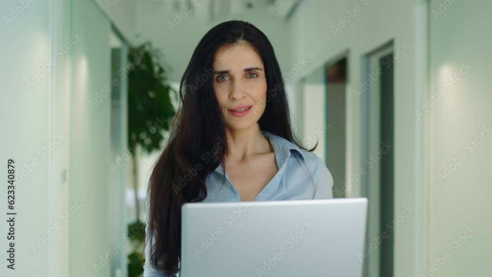 Attractive Female Manager Using Computer Standing with Laptop in Office Looking at Camera Attractive Female Manager Using Computer Standing with Laptop in Office Looking at Camera