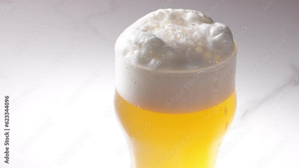foam on the beer pouring in glass close up foam on the beer pouring in glass close up