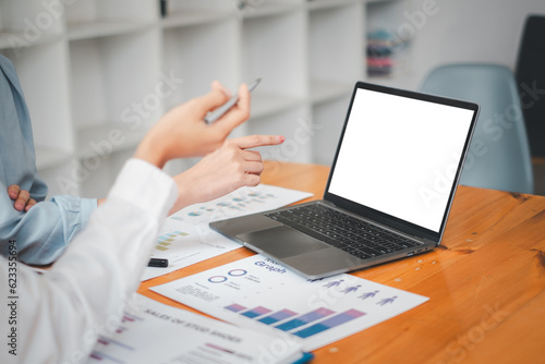 Close-up back view of a business team working in the office,  looking at the screen. office worker using a notebook computer.