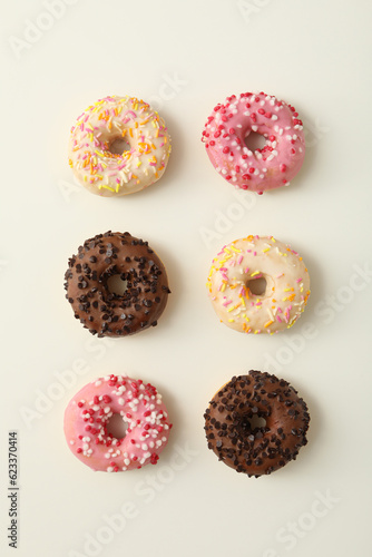 Chocolate, white and pink donuts on white background, top view