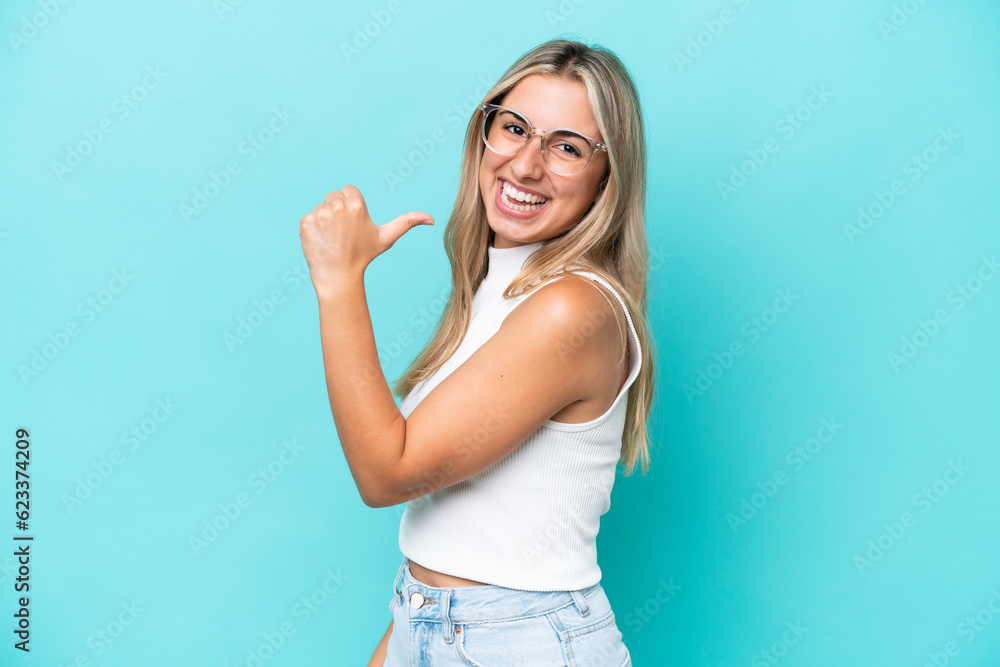 Fototapeta premium Young caucasian woman isolated on blue background proud and self-satisfied
