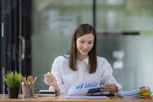 A businesswoman and accountant read reports for information, financial data, or analysis. Documents, auditor, and happy female professional check contracts, review, and bookkeeping in the office.