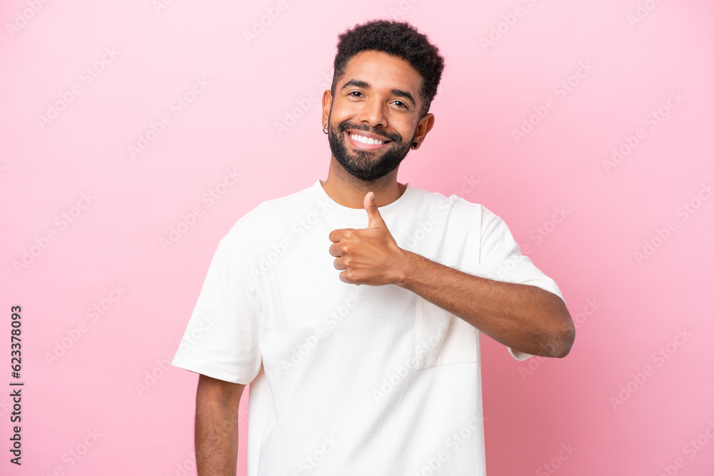 Young Brazilian man isolated on pink background giving a thumbs up gesture Young Brazilian man isolated on pink background giving a thumbs up gesture